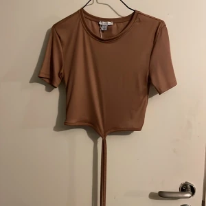 Brun tröja med snörning - Brun ribbad långärmad med snörning från Amisu. Helt ny med prislapp kvar. Storlek M.