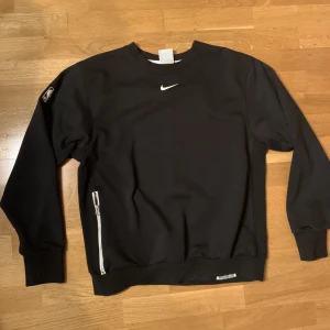 Nike tröja - Svart Nike sweatshirt med ficka på magen. Storlek m, bra skick. Perfekt nu till hösten/vintern! 120kr+frakt