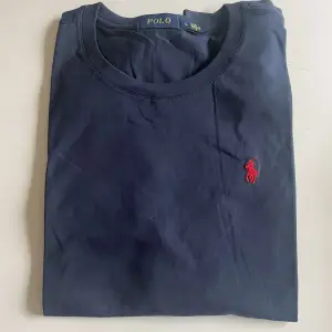 Blå Polo T-shirt med röd logga Oanvänd skick, pris kan alltid diskuteras vid snabba köp!