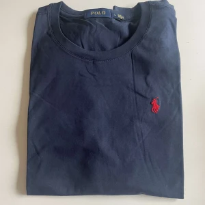 Polo T-Shirt - Blå Polo T-shirt med röd logga Oanvänd skick, pris kan alltid diskuteras vid snabba köp!