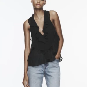 Svart festtopp öppen rygg - Tröjan sitter runt nacken och har låg rygg, något genomskinlig men väldigt snygg. Oanvänd strl M