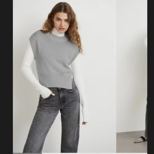 Stickad väst - En stickad väst från Ginatricot i storlek M. Västen är grå och har en slits på sidorna. Knappt använd. Pris som ny: 279:-