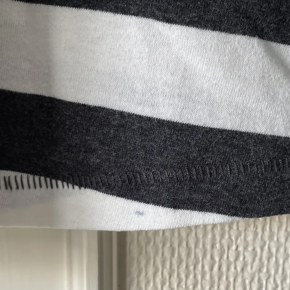 Långärmad tröja från Lager 157 med breda vita och gråsvarta ränder. Superskön! Tyget är lite ”nopprigt” i sig. Det finns en liten fläck vid fållen i bak men det är inget som märks direkt. Nästintill oanvänd! . Toppar.