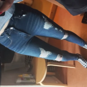 Jeans med paperbagmidja - Skitsnygga jeans i mörkblått tyg med stretch, slitningar framtill samt paperbagmidja. De är endast använda och tvättade en gång, så i absolut nyskick. Storlek S, passar mig bra som vanligtvis har 36-38. Högmidjade och 96 cm långa. Endast 50 kr! 