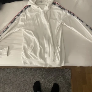 MOSHINO - MOSHINO kofta inta andvänd så mycket då jag köpte fel storlek (XS/S) INGA SNÖREN TILL LUVAN. Inga fläckar och inte trasig. Köpt på väla Urban modern. ORDIANRE PRIS 2500