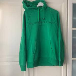 Grön Peak Performance - hoodie med luva och en ficka vid magen. Luvan har snören som är uttagbara. Mycket fint skick och mycket varm. Storlek L. 
