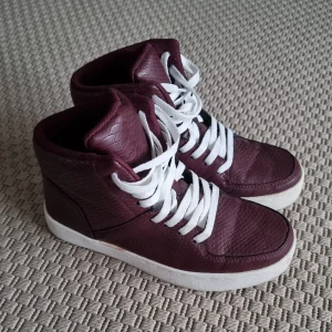 Sneakers  - Vinröda fodrade sneakers i ormskinnsmönster. 