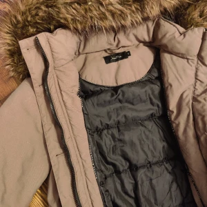 Vinterjacka - Jeane Blush vinterjacka i brun färg med fusk päls i huvan. Super varm och bekväm.