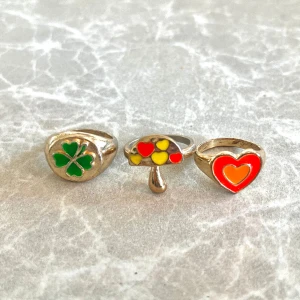 Söta ringar - Säljer tre söta ringar 🍄🍀💗  Lite slitna i metallen men själva framsidan av märkena är helt fina, så det är inget som märks supermycket!  30 kr styck eller 80 kr för alla. Vid snabbt köp går pris att diskuteras🥰