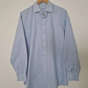 Ljusblå skjorta från Lee Baron (exlusively hand made by Lee Baron). Uppskattad herrstorlek Large. 