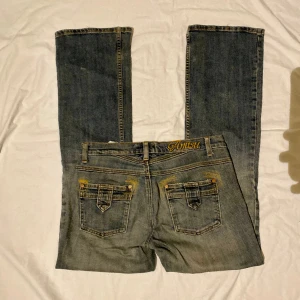 Vintage jeans - Vintage jeans, lågmidjade, bootcut. Midja: 39cm. Grenmått: 19,5cm. Lår: 26cm. Innerbenslängd: 81cm. Benöppning: 24,5cm.