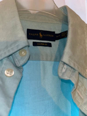 RALPH LAUREN SKJORTA CUSTOM FIT - Super fin, ljus blå skjorta som är figur sydd och i storlek S men kan även passa XS. Super fin till sommaren eller kontoret
