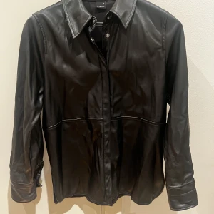 Skjorta i skinn imitation  - Svart skjorta i skinn imitation med knappar 