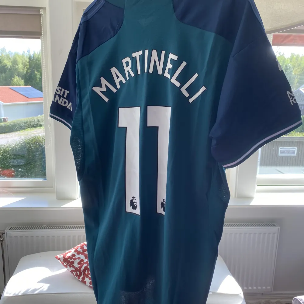 Arsenal tredjeställ denna säsong i nyskick med Martinelli #11 på samt Premier League badge. T-shirts.