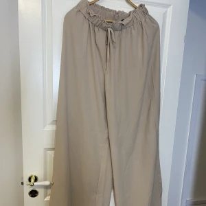 Byxor  - Två beiga luftiga byxor aldrig använda. 500 för båda  
