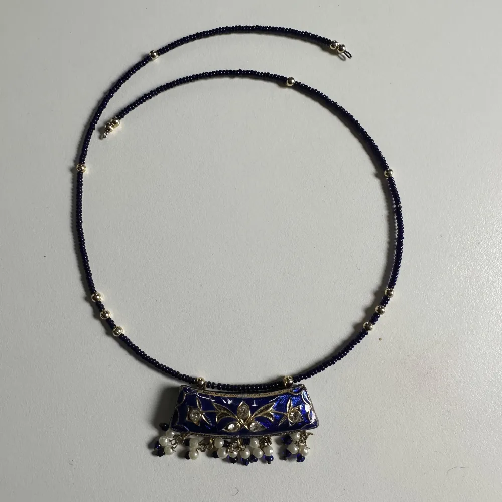 Blue necklace with gold details.. Accessoarer.