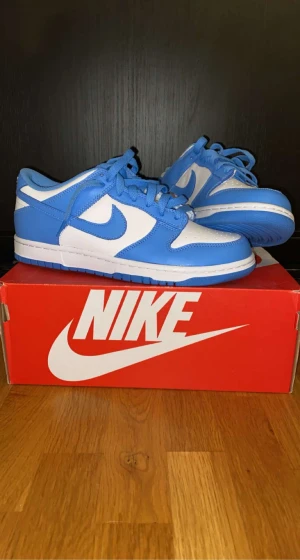 Nike Dunk Low UNC 2021 (GS) - Säljer helt nya nike dunk low UNC (GS) som kom på 2021. Det är väldigt snyggt på fötter plus jätte sköna. Tyvärr kunde jag inte hitta kvitto:( För mer info dm;)