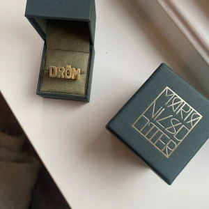 Maria Nilsdotter drömring - Maria Nilsdotter dröm ring i guld i storlek 16. Ringen går ej att få tag på längre och är i fint skick. Box och ytterbox medföljer.