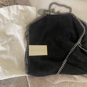 Stella McCartney falabella  - Hej!  Superfin väska från Stella som tyvärr inte blir använd.  Storlek medium. Har fäst ett axelband och använt den så.  Nypris ca 11 000:-