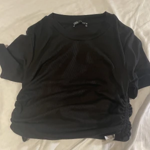 Zara topp med snören  - Säljer en oanvänd zara topp med hängande snören på sidan. Säljs inte längre på Zara hemsidan, i storlek M