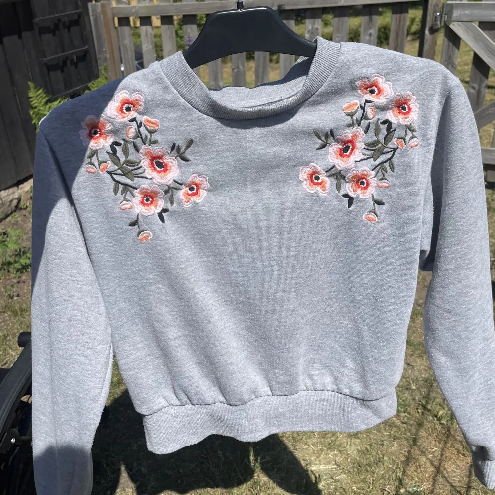 ⚠️Smutsig spegel⚠️ En fin grå sweatshirt med blommor vid axlarna. Den har använts en del men inga tecken på användning finns.  Referens: jag bär vanligtvis M.. Tröjor & Koftor.