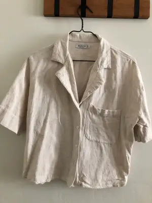 Good condition, short sleeved shirt with pocket detail. Fabric is linen cotton mix, the length of the shirt is around belly button