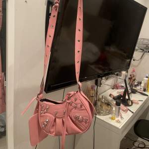 En balenciaga liknande väska i färgen rosa. Bandet är justerbart så man kan göra den kortare också om man vill. Köpt för 456kr men säljer för 250kr. Pris kan diskuteras💞