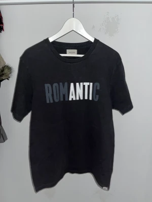 wood wood romantic t-shirt - riktigt edgy wood wood tisha med ett print där det står ”romantic”. vitsen är dock att bokstäverna A, N, T, och I är i en annan färg (vit) än de andra svarta bokstäverna som smälter in i tishan. det gör att ”anti” sticker ut, för man e anti romans, pain💔🖤