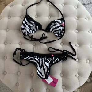 Bikini - Bikini från chynnadolls. Överdelen i storlek M/L Underdelen i storlek S/M. Jag skulle rekommendera bikinin till någon som har XS/S. Underdelen är scrunch och har prislapp o trosskydd kvar. Aldrig använd och inga skavanaker.