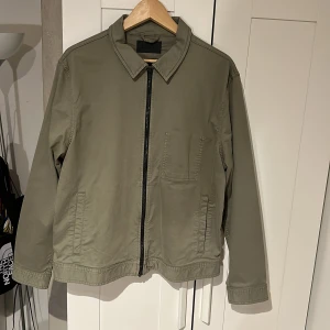 Elvine jacka - Snygg grön jacka från Elvine med svart dragkedja perfekt inför sommaren, aldrig använd och skick 10/10, nypris 2499kr
