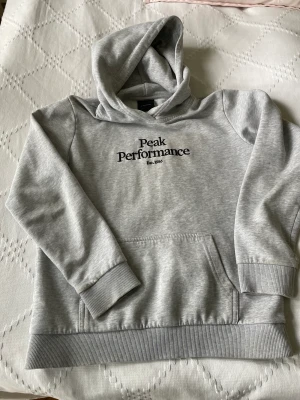 Peak performance hoodie  - Peak performance ljusgrå hoodie stl 150. Använt skick liten flöck vid ena ärm-mudden, se bild