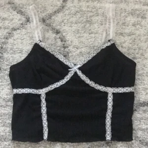 Svart spetslinne - Svart linne med vit spets och rosett. Aldrig använt!