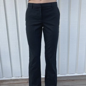 Lågmidjade kostymbyxor  - Lågmidjade kostymbyxor från STOCKHLM i strl 34, fållen längst ner på benen är sprättad för att de ska bli längre