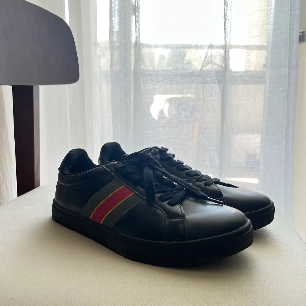 Svarta sneakers med guccis färger på sidan. Använt 1 gång. Köpt via zalando . Skor.
