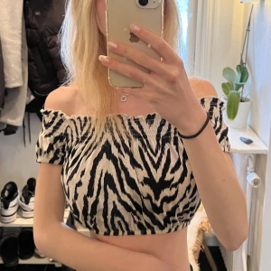 Sommartopp - Off-shoulder topp i zebramönster från Ginatricot. Använd fåtal gånger så väldigt bra skick. Normal i storlek
