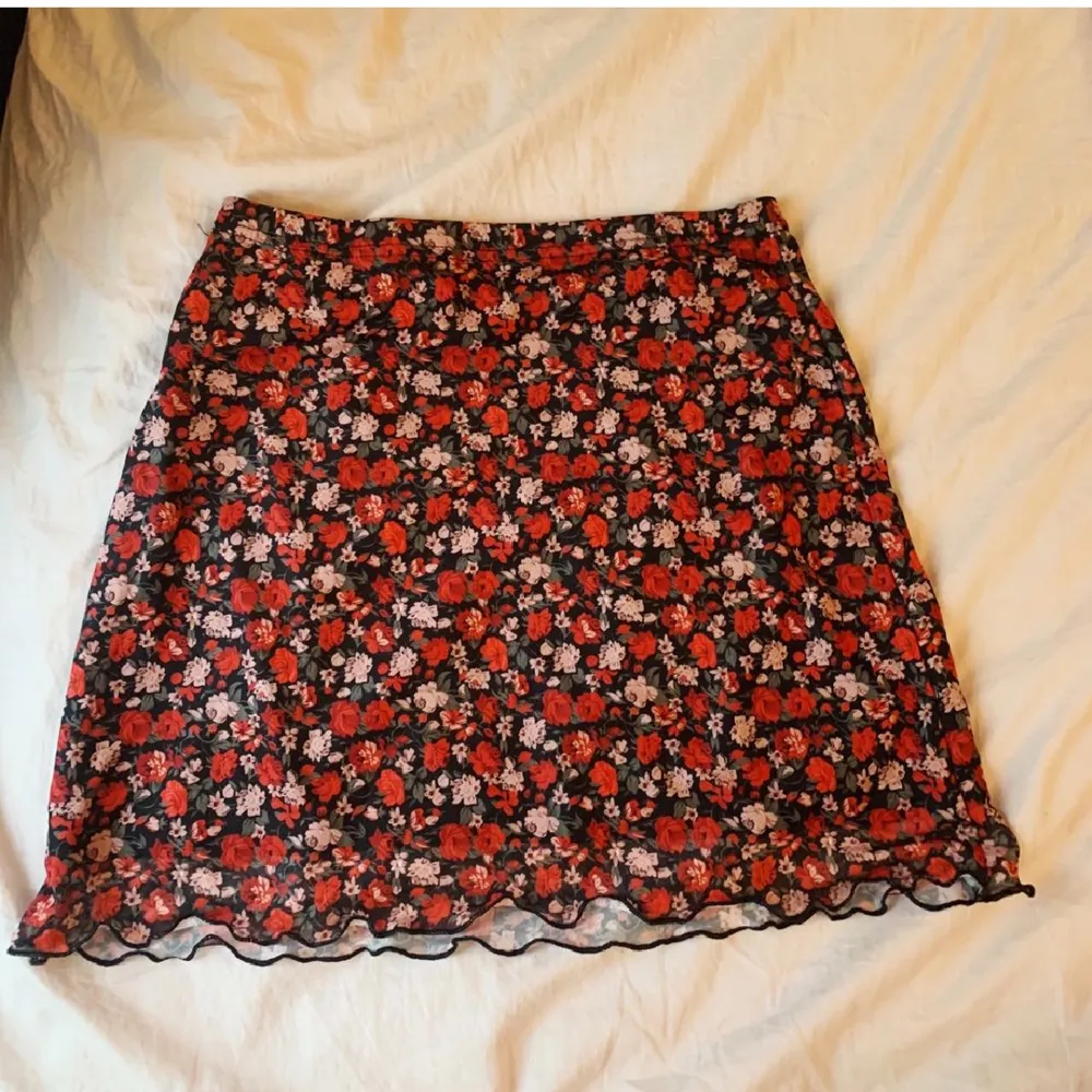 Röd blommig kort kjol, pefekt för sommaren. Säljer pga har blivit för liten😔. Kjolar.