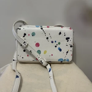 Desigual väska - Liten cross body väska  Vit med färg fläckar på  Söt till sommaren  Från Spanien  Haft den i några år men har inte använt den så mycket och den är i jättebra skick 