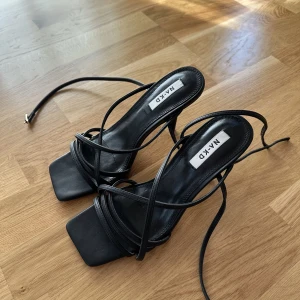 Klackskor med remmar - Svarta högklackade remsandaler i storlek 38. Aldrig använda, från NAKD. 