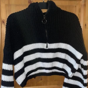 Stickad tröja  - En vitrandig stickad tröja med kort kedja vid halsen. Säljs på grund av att den tyvärr inte kommer till användning 