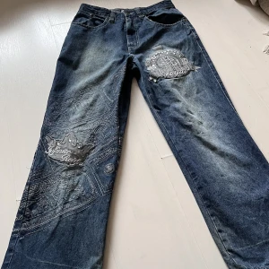 Raw blue jeans  - Underbara raw blue jeans. Dom har broderade sedlar över fram och backsidan, grå plast tryck med kristaller på, en Kristall är lite lös😋 Slitna vid fötterna men i övrigt bra skick🫶🫶 middemått: 81 cm innerbensmåttet: 71cm