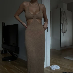 Strandklänning - Strandklänning med cutouts och knyta i ryggen + nacken. Genomskinligt tyg så snyggast med bikiniunderdel under. 