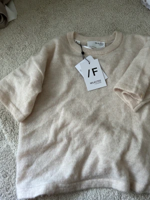 Stickad T-shirt  - Stickad T-shirt från selected femme, merinoull. Aldrig använd lappar kvar. Storlek M, men rekommenderar till storlek S. Denna finns ej kvar längre. 