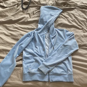 Juicy Counture kofta - Säljer denna snygga ljusblåa Juicy Couture kofta då den inteckningar till användning! Är i storlek L men passar mig som brukar ha storlek XS/S och är 168 cm lång. Aldrig använt så i princip helt nyskick. Köp på Raglady