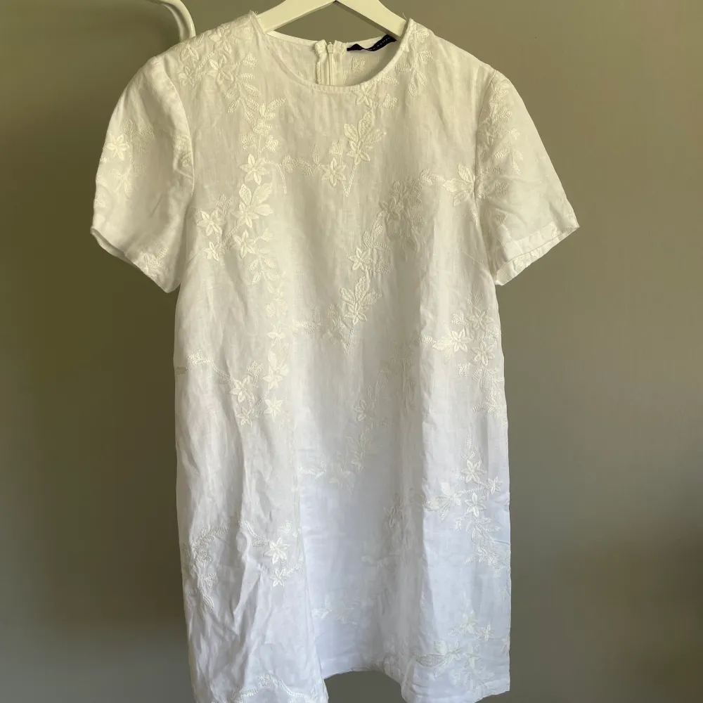 Jättesöt vit Tshirt-klänning från Zara. Med vita, broderade blommor och dragkedja i bak. Skriv för fler bilder! . Klänningar.