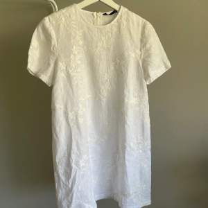 Jättesöt vit Tshirt-klänning från Zara. Med vita, broderade blommor och dragkedja i bak. Skriv för fler bilder! 