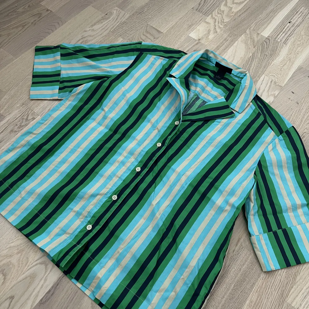 En oversized randig kortärmad skjorta i storlek S från Monki. Aldrig använd, endast testad. Har även matchande byxor till. Går bra att få samfraktat, paketpris för båda 250kr. Inköpta för 500kr. Styckpris 150kr.. Skjortor.