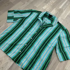 En oversized randig kortärmad skjorta i storlek S från Monki. Aldrig använd, endast testad. Har även matchande byxor till. Går bra att få samfraktat, paketpris för båda 250kr. Inköpta för 500kr. Styckpris 150kr.