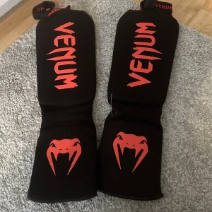 Venum benskydd thaiboxning  - Svarta röda benskydd från Venum 