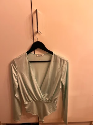 Turkos body - Turkos långärmad body från Nelly.com. Aldrig använd bara provad några gånger men aldrig passat mig i smaken