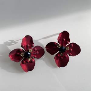 Säljer dessa blomfärgade örhängen i rött med en svart sten i mitten. Knappt använda och i fint skick☺️